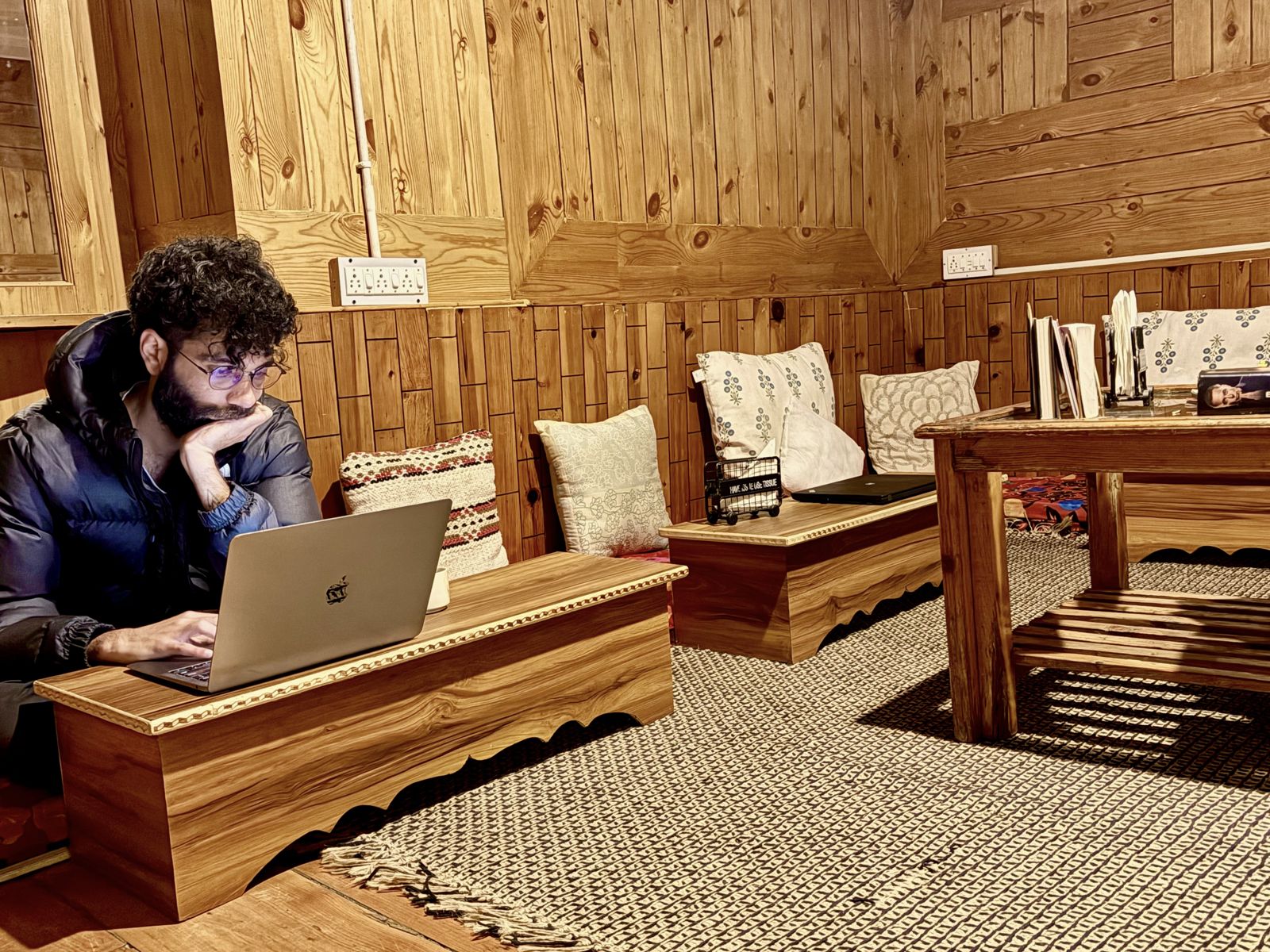 Guest working on a laptop at a low desk in the wood-panelled lounge at Misfits