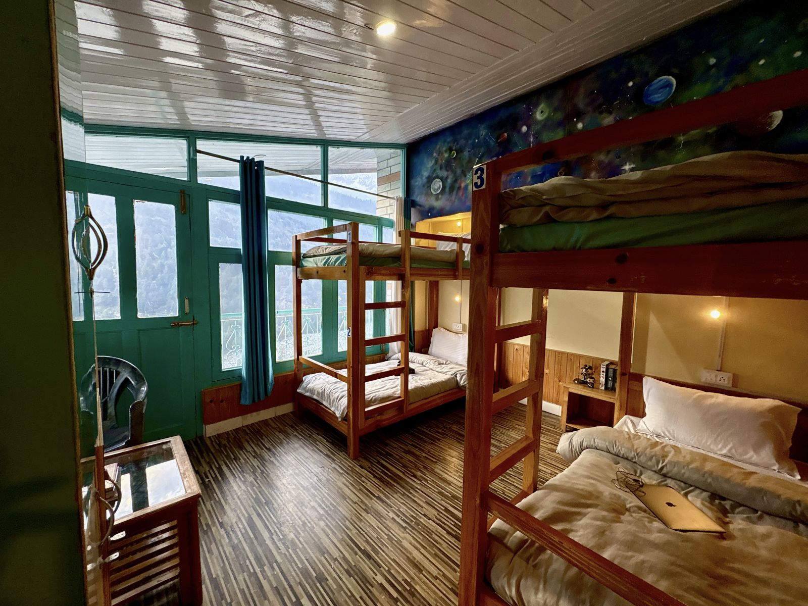 Dorm with bunk beds and a window facing the mountains at Misfits