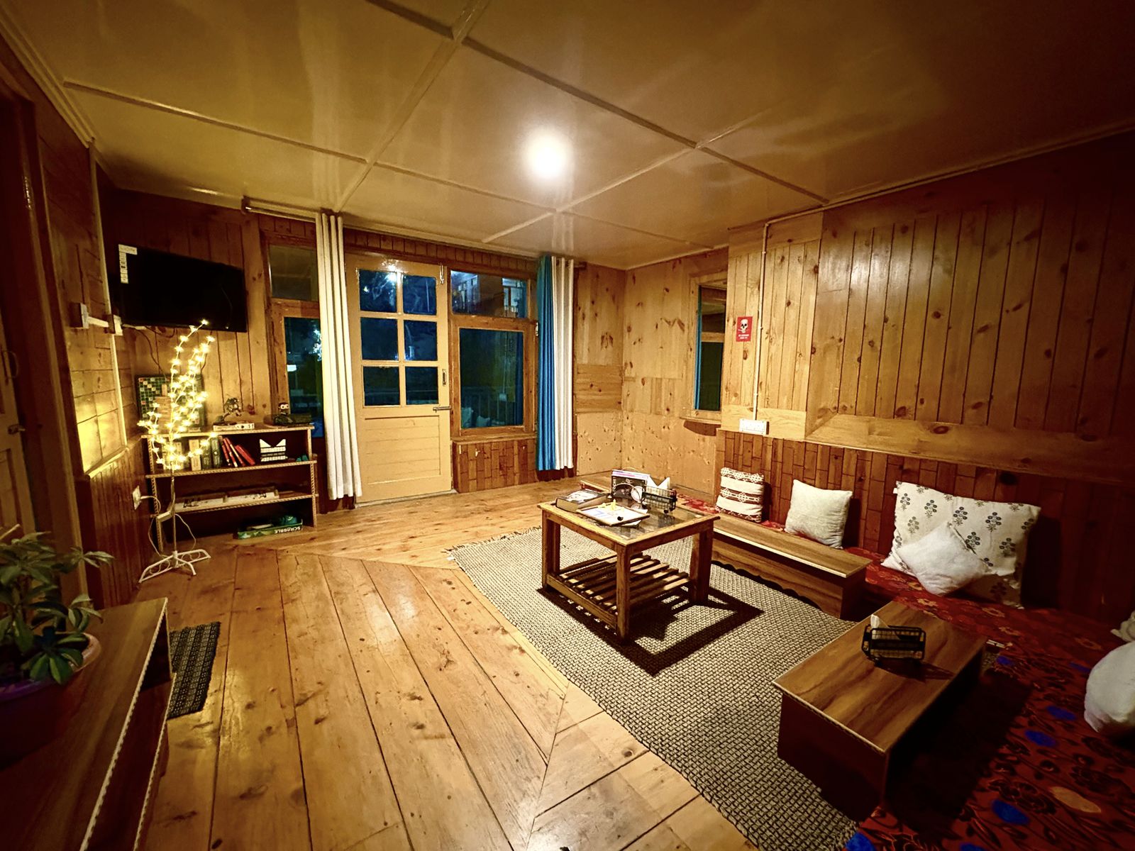 Wood-panelled common lounge with seating and fairy lights at Misfits
