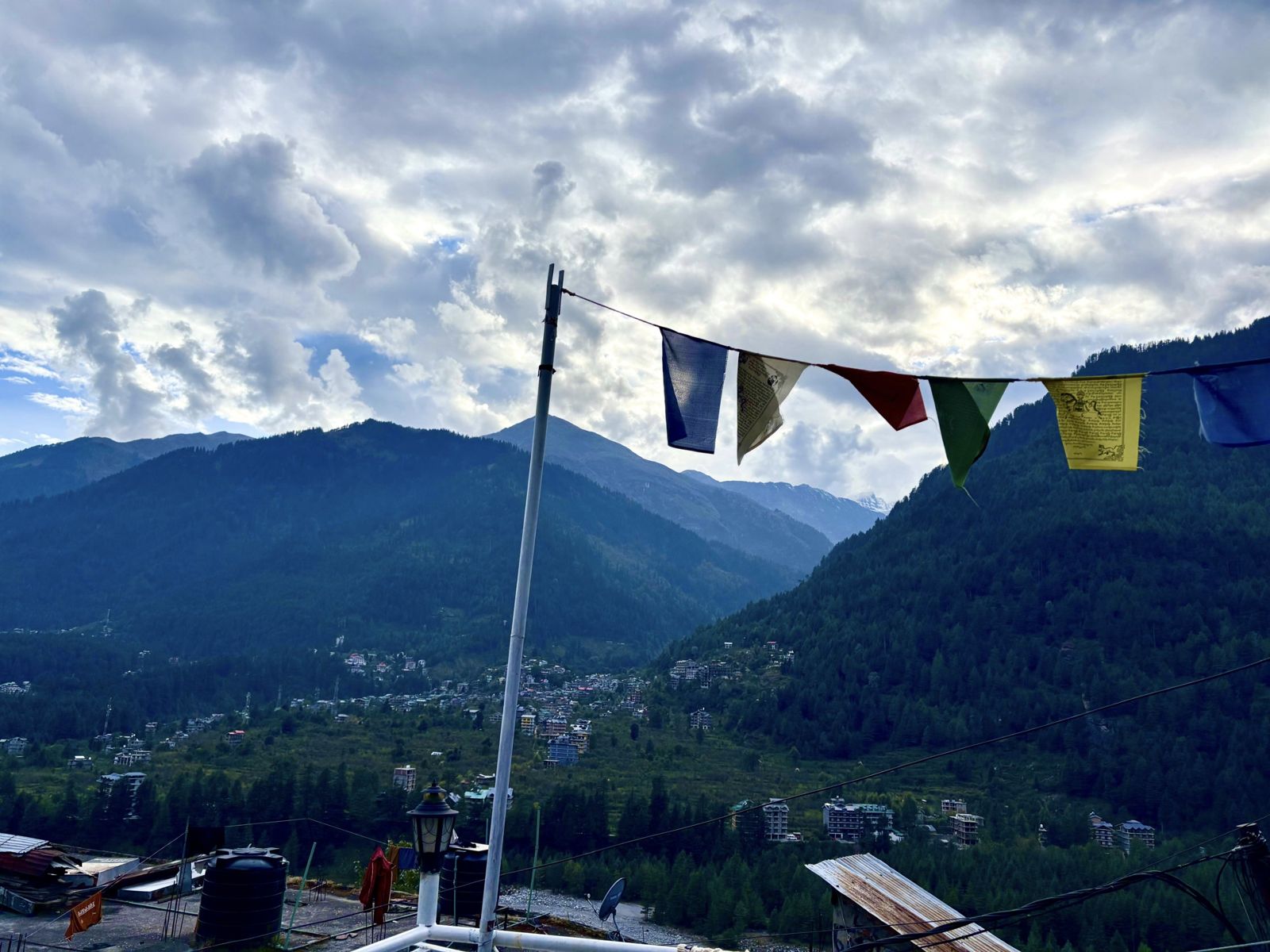 Prayer flags and pine-covered mountains above Vashisht